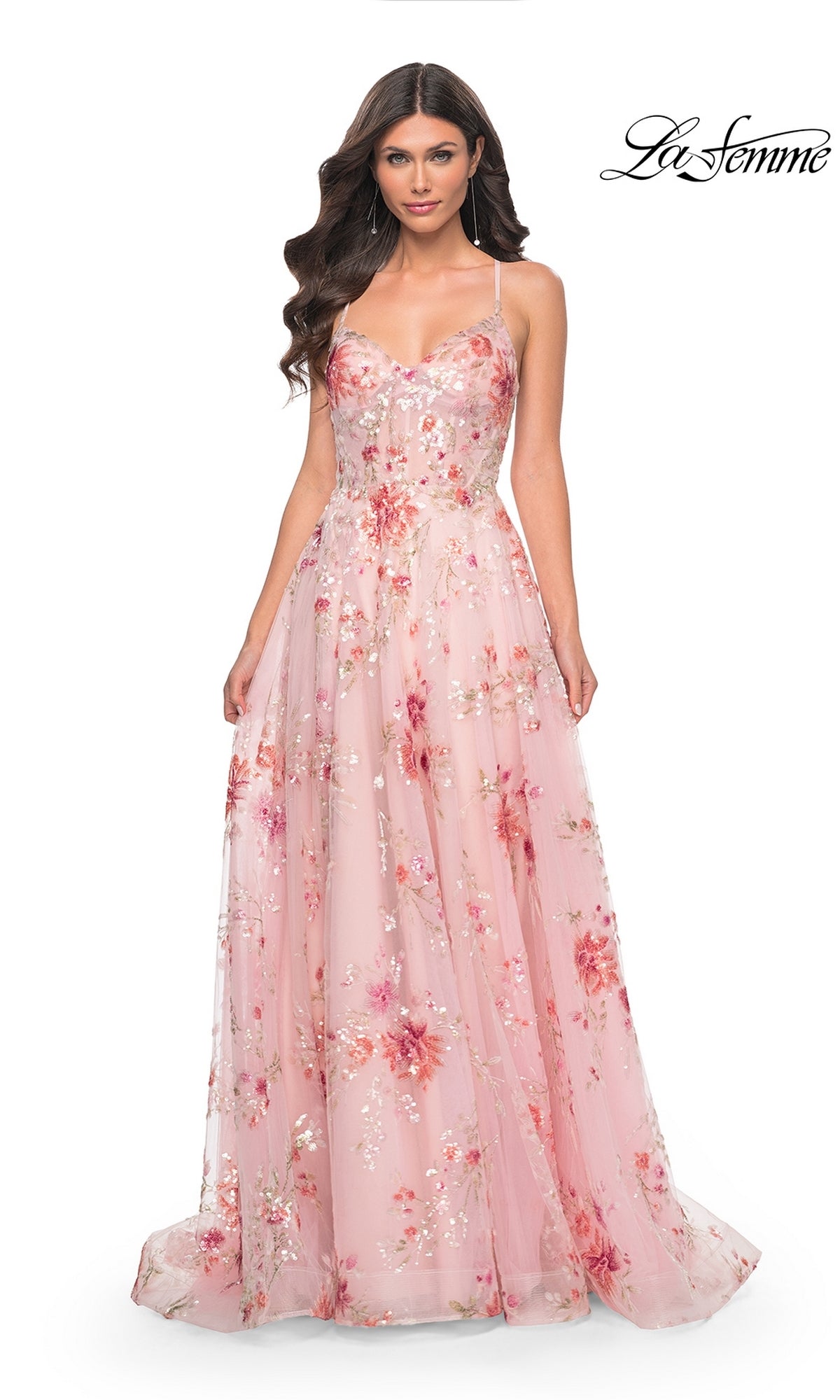 A woman stands against a white background wearing the La Femme Floral-Sequin Long A-Line Prom Dress 32031, featuring a pink floral print, fitted bodice, and flowing skirt. The